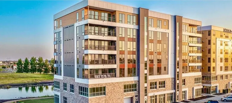 MAKT at EOLA exterior with apartment balconies, ground-floor access points, and lit windows